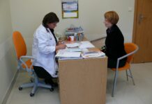 Pacjent i jego bezpieczeństwo warunkiem odpowiedzialnego rozwoju gabinet lekarski: lekarka wypisuje receptę a pacjenta siedzi naprzeciw niej