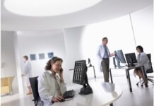 Szanse i zagrożenia dla e-zdrowia na podstawie węgierskich doświadczeń dział IT Healthcare. Pielęgniarka siedzi za biurkiem, rozmawia przez telefon, na monitorze obaz z TK, w tle lekarz i inny technik