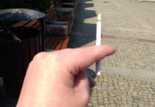 Chorzy onkologicznie nie chcą rzucać palenia damska ręka trzyma cienkiego, zapalonego papierosa