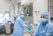 Produkcja leków – odporny na kryzysy sektor fabryka GSK w Poznaniu, pracownicy pracujący w reżimie sanitarnym