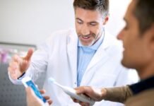 Specjalizacja w dziedzinie psychoterapii nie dla lekarzy dentystów? dentysta tłumaczy pacjentowi jak korzystać z elektrycznej szczoteczki do zębów
