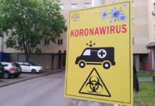 NIK: Wiarygodność informacji w czasie epidemii COVID-19 pod znakiem zapytania tablica informacyjna, na żółtym tle napis koronawirus, czarny ambulans i znak zagrożenie biologiczne
