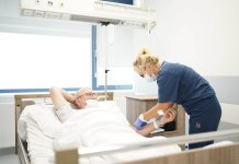 KOS-zawał to szansa dla chorych kardiologicznie sala szpitalna, pielęgniarka pochyla się nad pacjentem