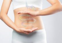 Zapalne choroby jelit zmieniają życie kobieca sylwetka, jedna ręka z góry a druga z dołu brzucha na którym narysowane są jelita