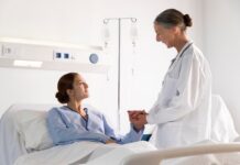 Żywienie medyczne może obniżyć koszty hospitalizacji nawet o 36% pacjentka w szpitalu, leży w łóżku lekarka stoi obok i trzyma ją za rękę