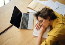 Nowa nadzieja dla pacjentów z tętniczym nadciśnieniem płucnym kobieta leży na biurku na rozrzuconych papierach przed nią otwarty laptop