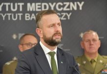 Kosiniak-Kamysz: Dla PSL obniżenie składki zdrowotnej „to sprawa fundamentalnej wagi” Władysław Kosiniak-Kamysz, wicepremier i minister obrony narodowej przemawia do mikrofonu, w tle banner z napisem Wojskowy Instytut Medyczny