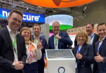 Medtech Prosoma wspierający pacjentów onkologicznych zyskał 1 mln euro zadowolona grupa ludzi zgromadzona wokół postumentu z napisem Prosoma podczas targów