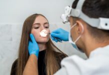 Leczenie biologiczne – rewolucja w terapii przewlekłego zapalenia zatok z polipami nosa lekarz sprawdza u pacjentki wnętrze nosa