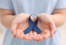 Rak jelita grubego rozwija się po cichu. A 43,7% Polaków nie zna jego objawów niebieska wstążka - symbol raka jelita grubego - trzymana w dłoniach