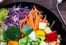 Roślinne posiłki w szpitalach? Nowy Jork przeciera szlaki, Wielka Brytania u progu zmian talerz z warzywami, obok sosy i stetoskop - ilustracja jedzenia roślinnego