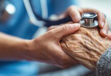 Problemy z finansowaniem opieki paliatywnej i hospicyjnej splecione ręce lekarza i senior. lekarz przykłada stetoskop do pomarszczonej dłoni