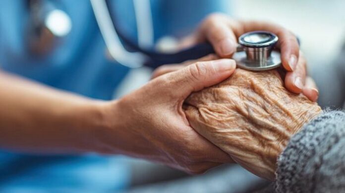 splecione ręce lekarza i senior. lekarz przykłada stetoskop do pomarszczonej dłoni