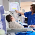 Prawie 21 tysięcy Polaków żyje dzięki dializom stacja dializ - pacjent siedzi na fotelu a pielęgniarka ustawia sprzęt