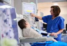 Prawie 21 tysięcy Polaków żyje dzięki dializom stacja dializ - pacjent siedzi na fotelu a pielęgniarka ustawia sprzęt